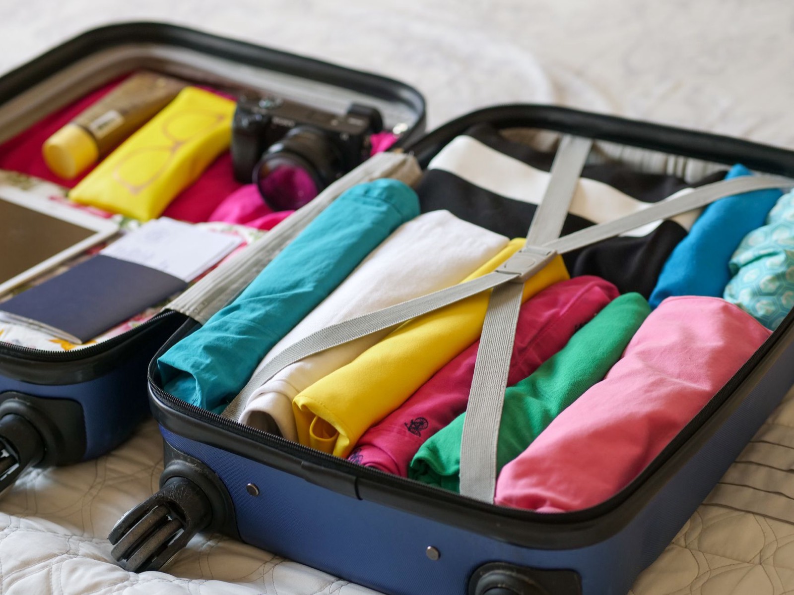 Valise ouverte avec checklist de voyage posée à côté